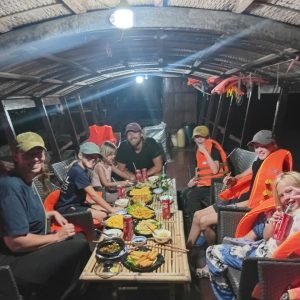 Tourists enjoying local dinner during Ben Tre boat tour