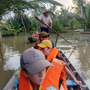 Tourist enjoying sunset boat tour in Ben Tre